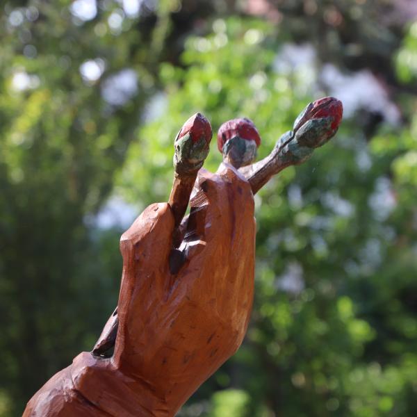 in der Hand drei Rosenknospen