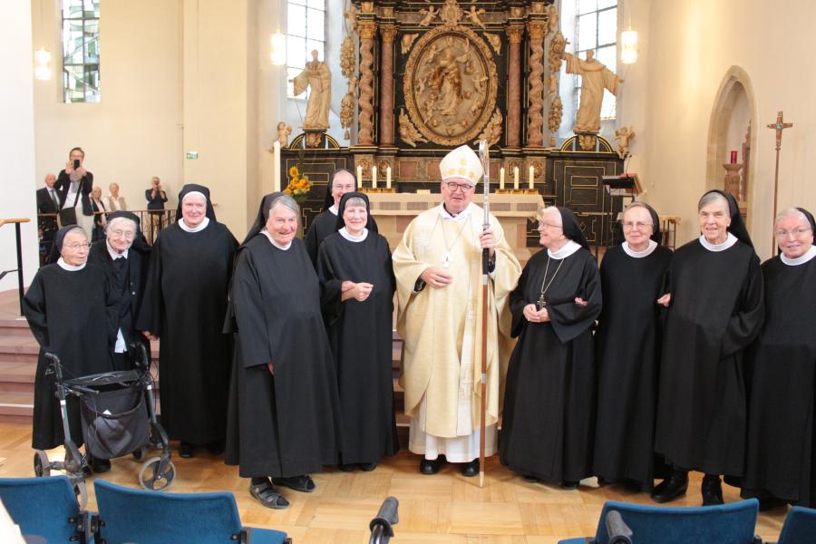 Gruppenfoto mit Bischof nach dem Gottesdienst, eine Schwester ist verdeckt